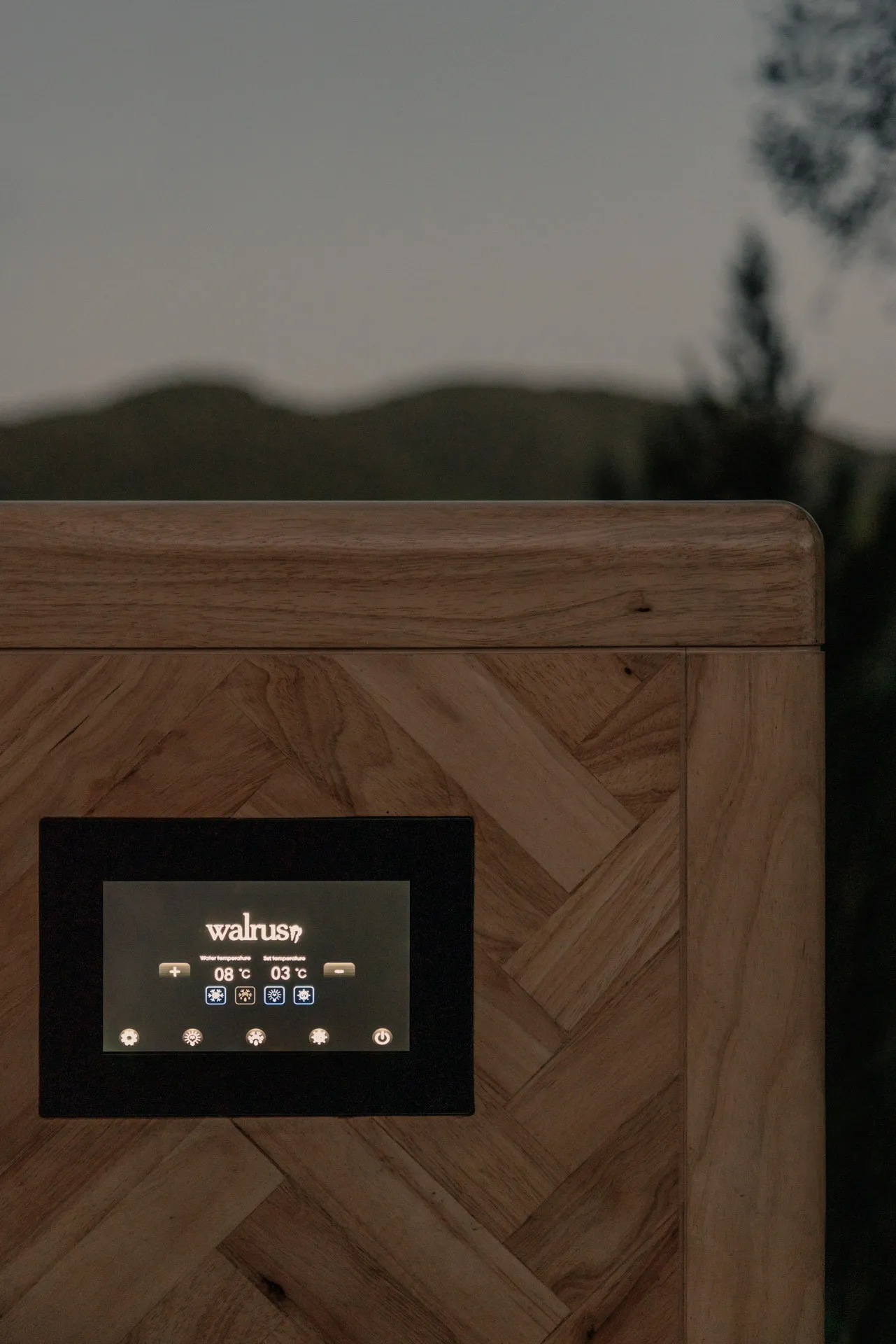 Close-up of a wooden hot tub control panel displaying water temperature at 8°C and set temperature at 3°C with illuminated icons.