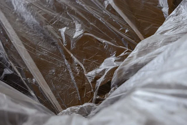 Close-up view of crinkled, translucent plastic sheet with textured folds and reflections.