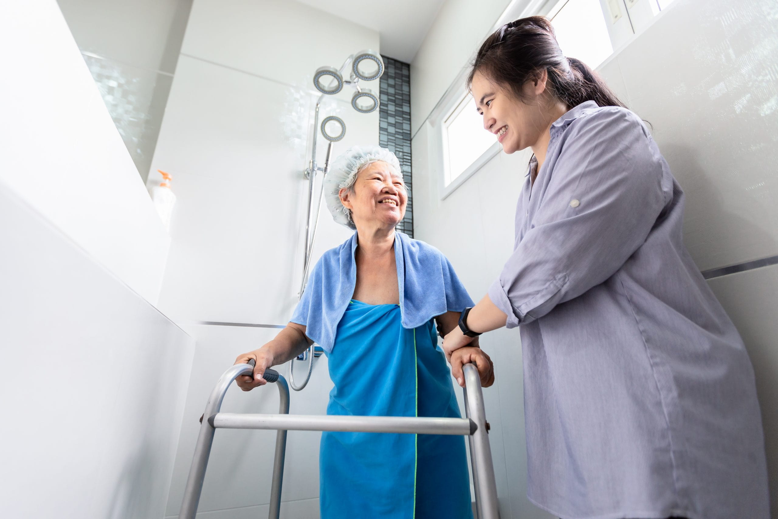 Caregiver getting ready to help an elderly woman take a shower.