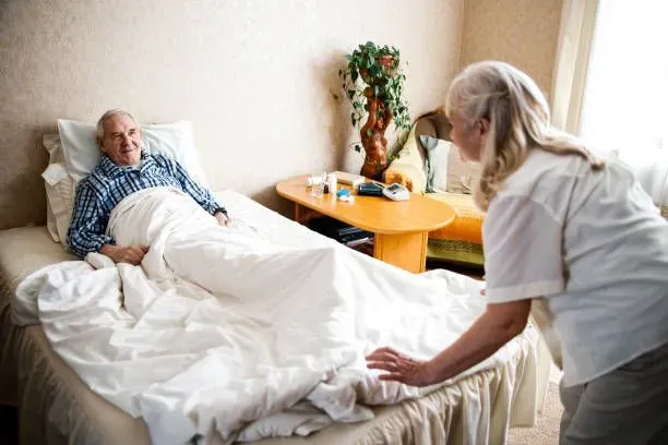 Caregiver caring for bed-bound senior.