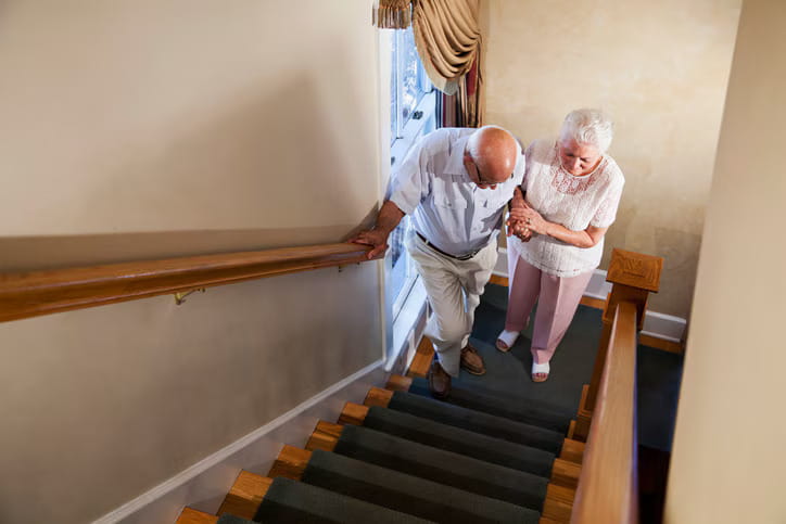 Caregiver preventing an elderly from falling.