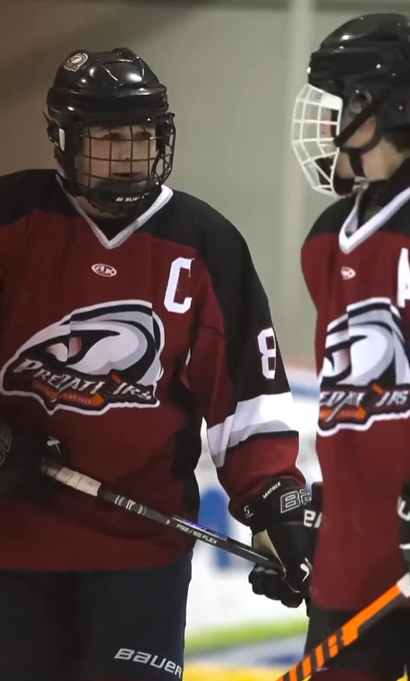 Two Bantam A hockey players from the Shediac/Cap-Pelé Predators team on the ice, sponsored by CLG Injury Law.