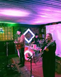 Live band performing at local Atlantic Canada music venue with colorful stage lighting