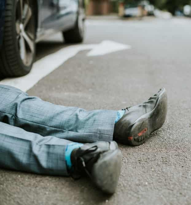 Workplace accident scene with injured construction worker lying on the floor and emergency response underway.