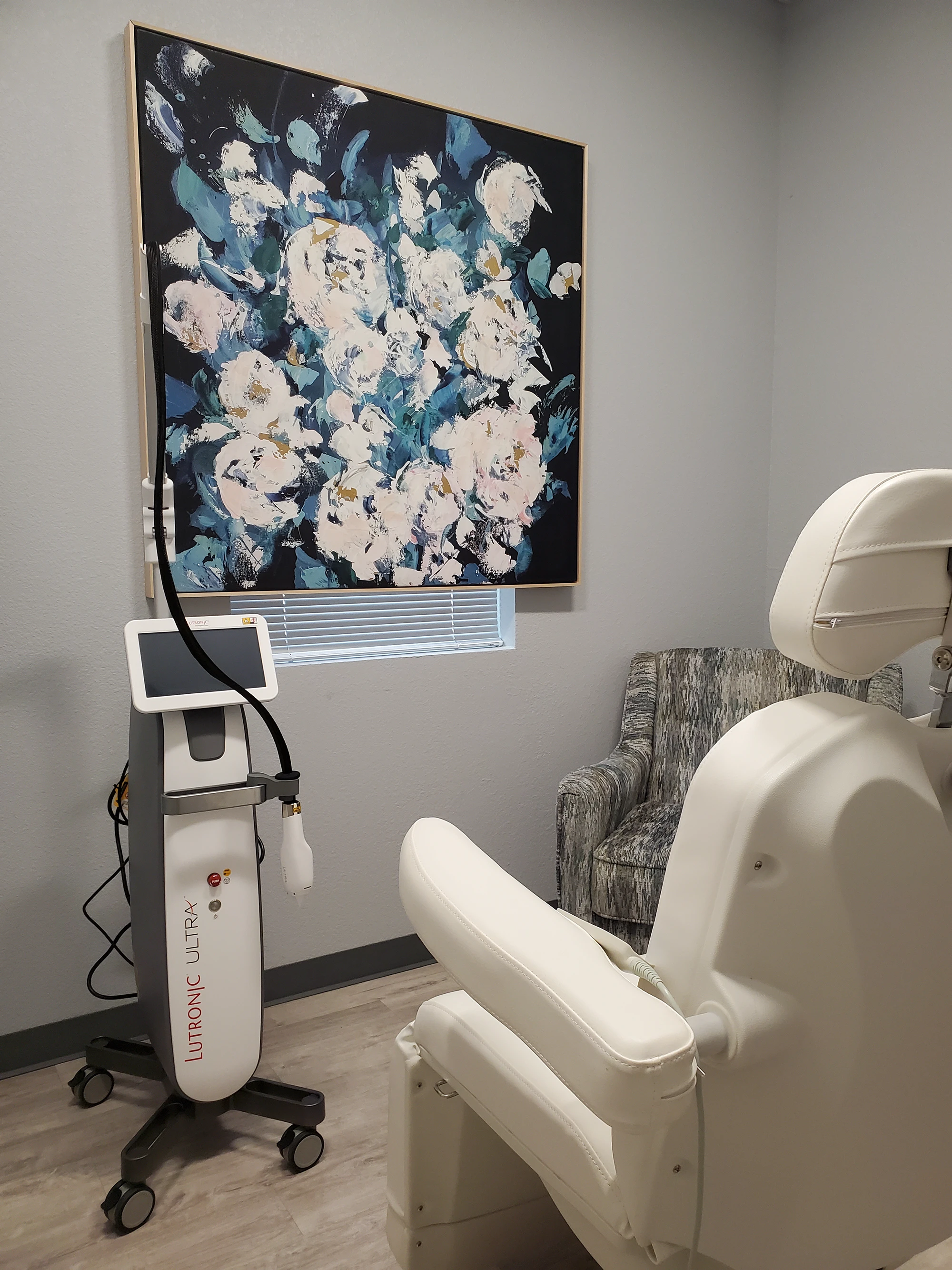 A room with a chair and a painting on the wall