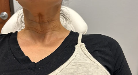 A woman sitting in a chair with her back turned to the camera