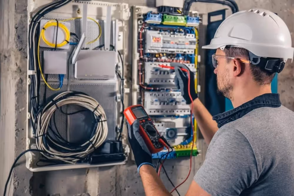 Electrician using multimeter on breaker panel.
