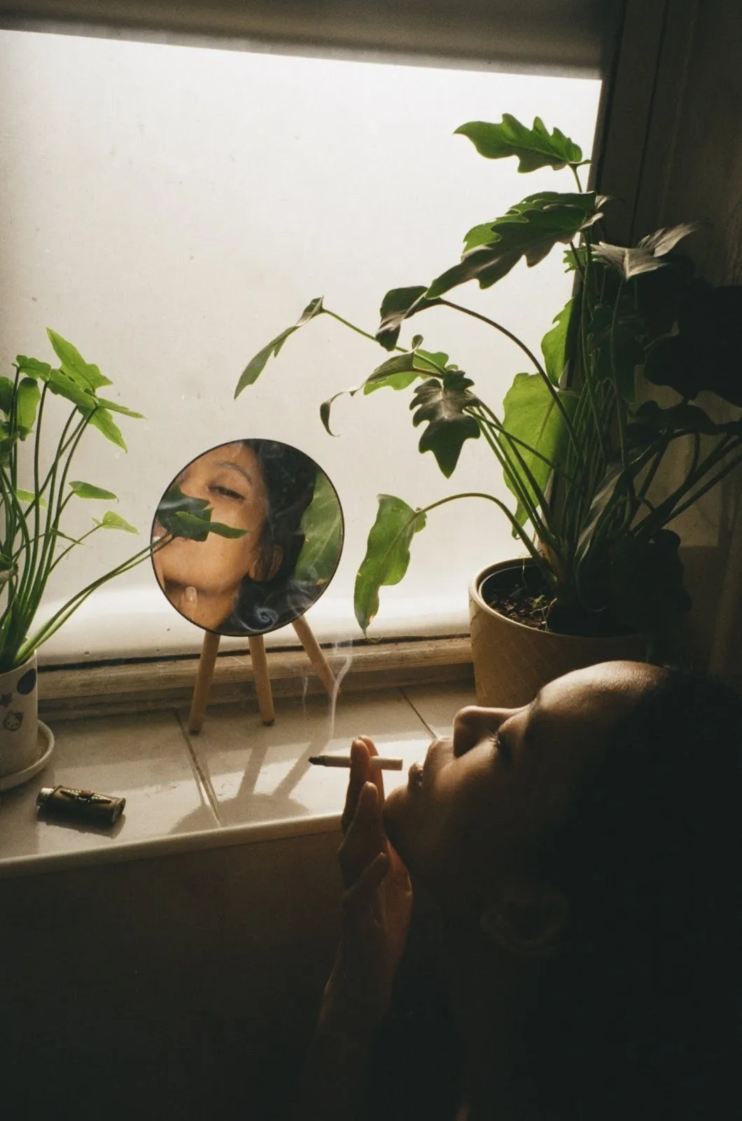 Asian woman smoking in front of mirror and plants in bathroom, Bea portrait by Morrison.