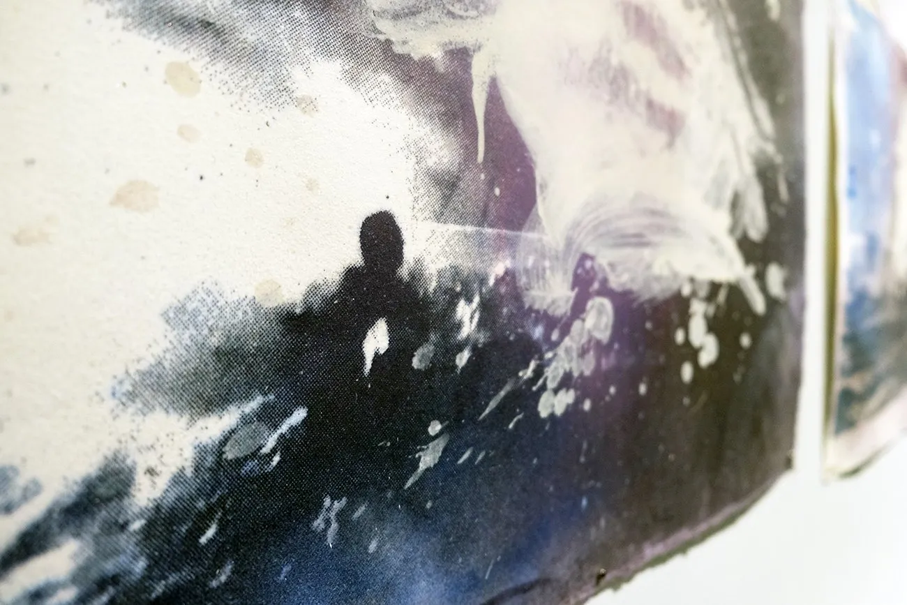 Detail of artwork False Dawn on gallery wall with ocean motif, collaged with cheesecloth depicting turbulent ocean with immigrant boats, Nazanin Noroozi.