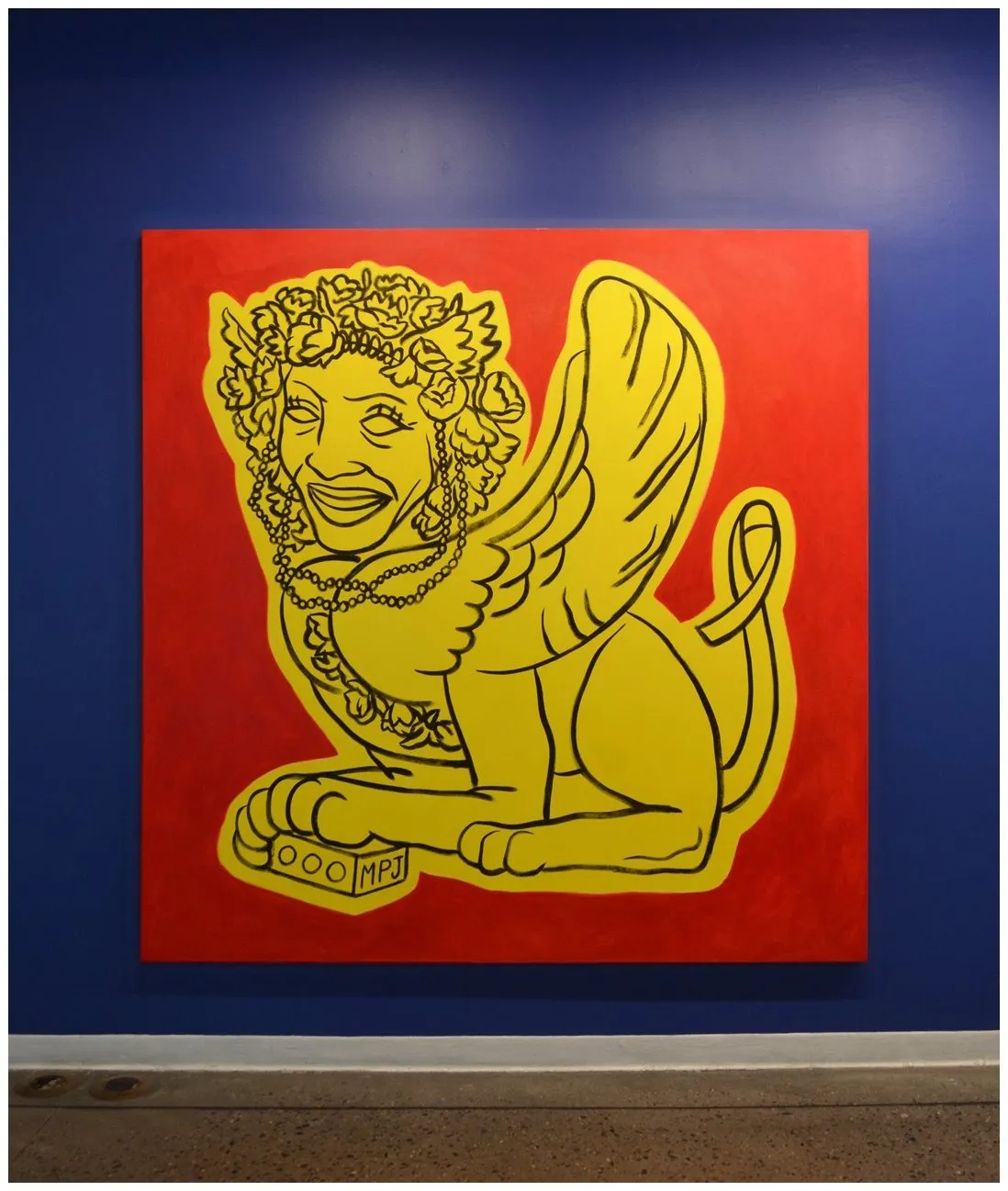 Gio Black Peter, large acrylic painting of yellow Sphinx against red background on blue gallery wall, AIDS awareness.