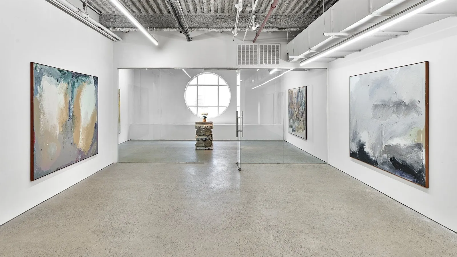 Abstract expressionist gestural paintings in EUROPA Gallery by Thomas McDonell with stack of newspaper sculpture and cut flowers in vase, Figueroa St paintings.