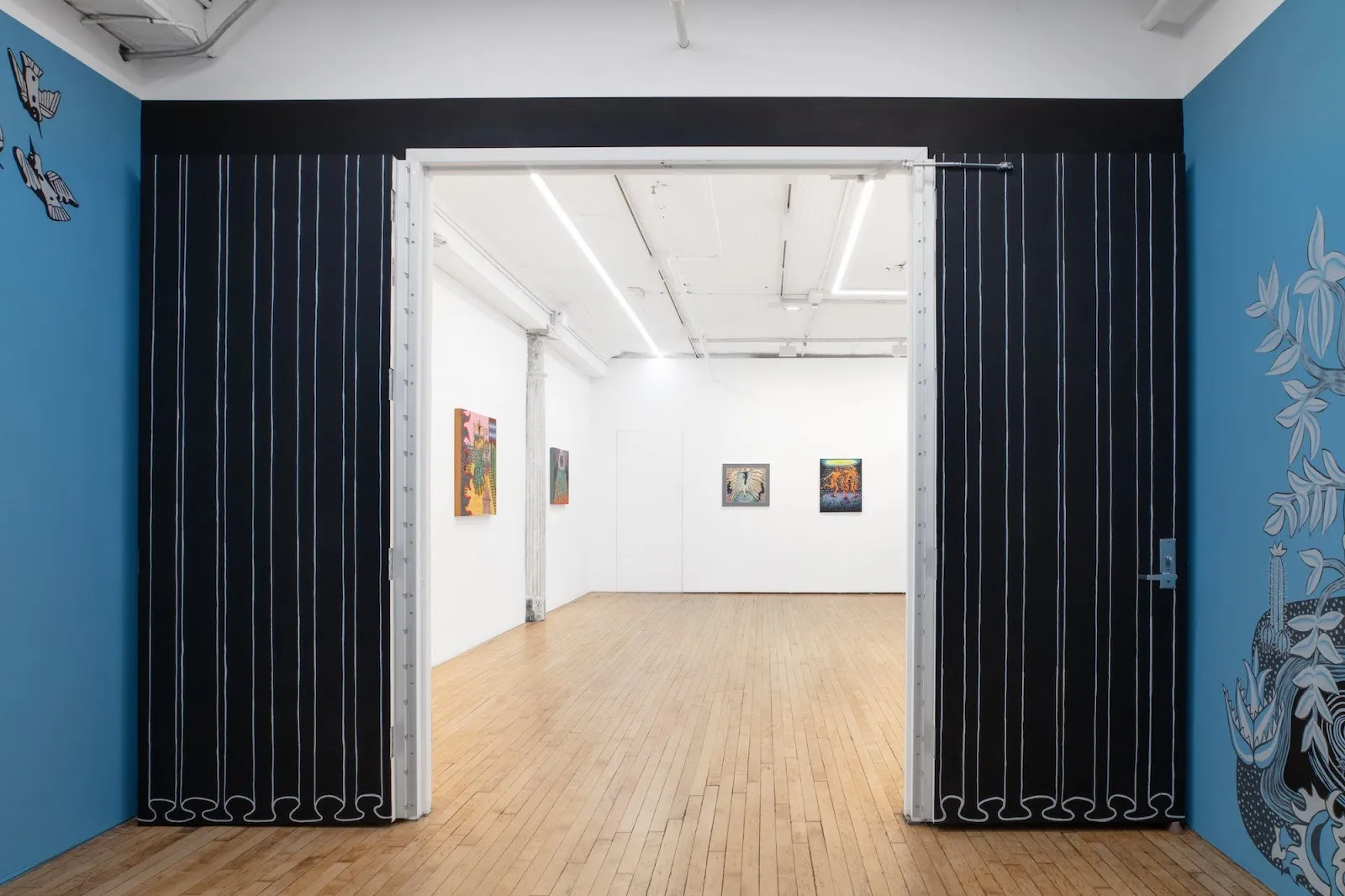 Installation view of site-specific mural for Tell Me How It Ends by Miguel Martinez, Gallery room with blue and white walls and black painted curtains.