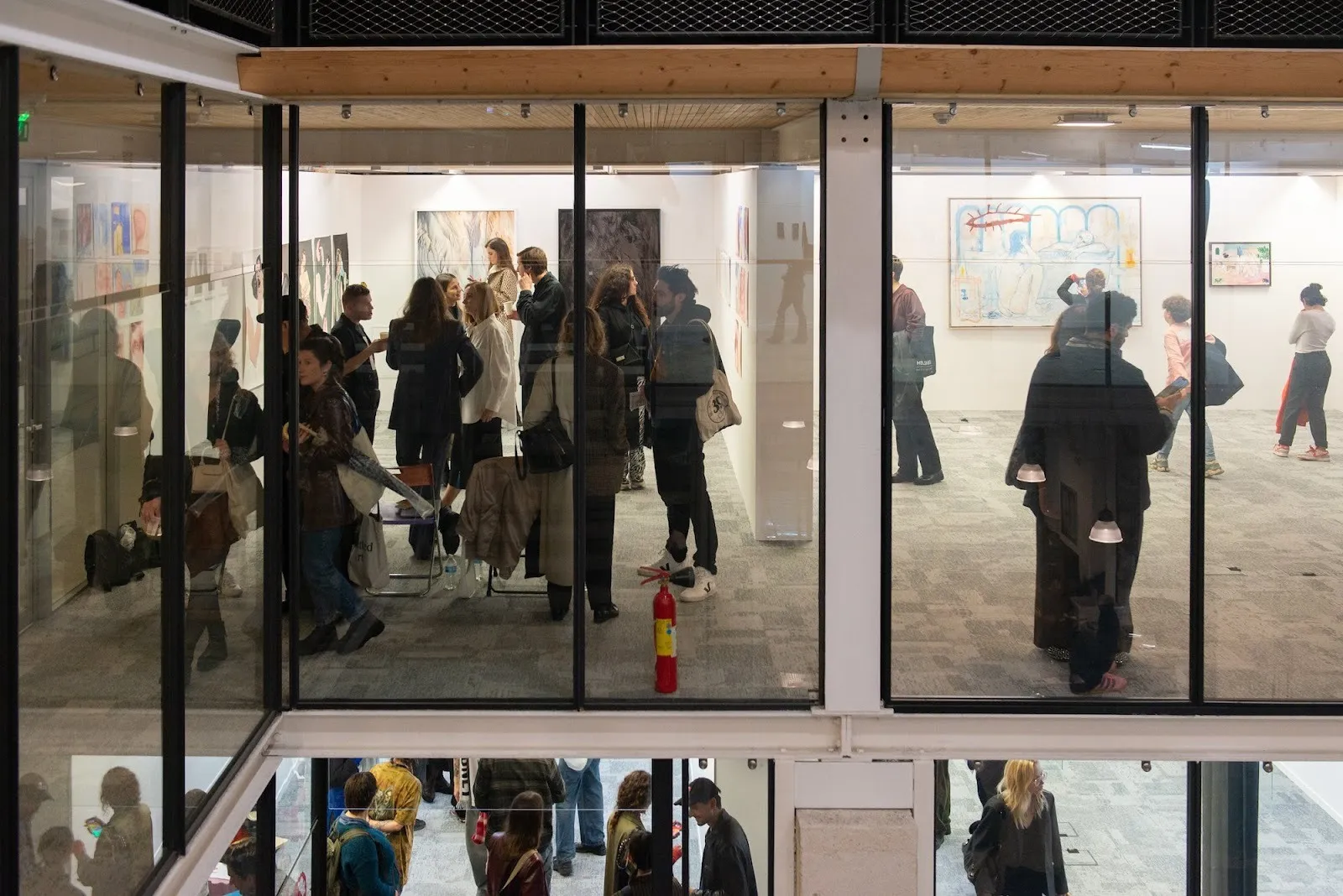 Installation aerial view of The Salon by NADA and The Community on opening day, crowds in glass and brick structured art building with exhibition booths from galleries.