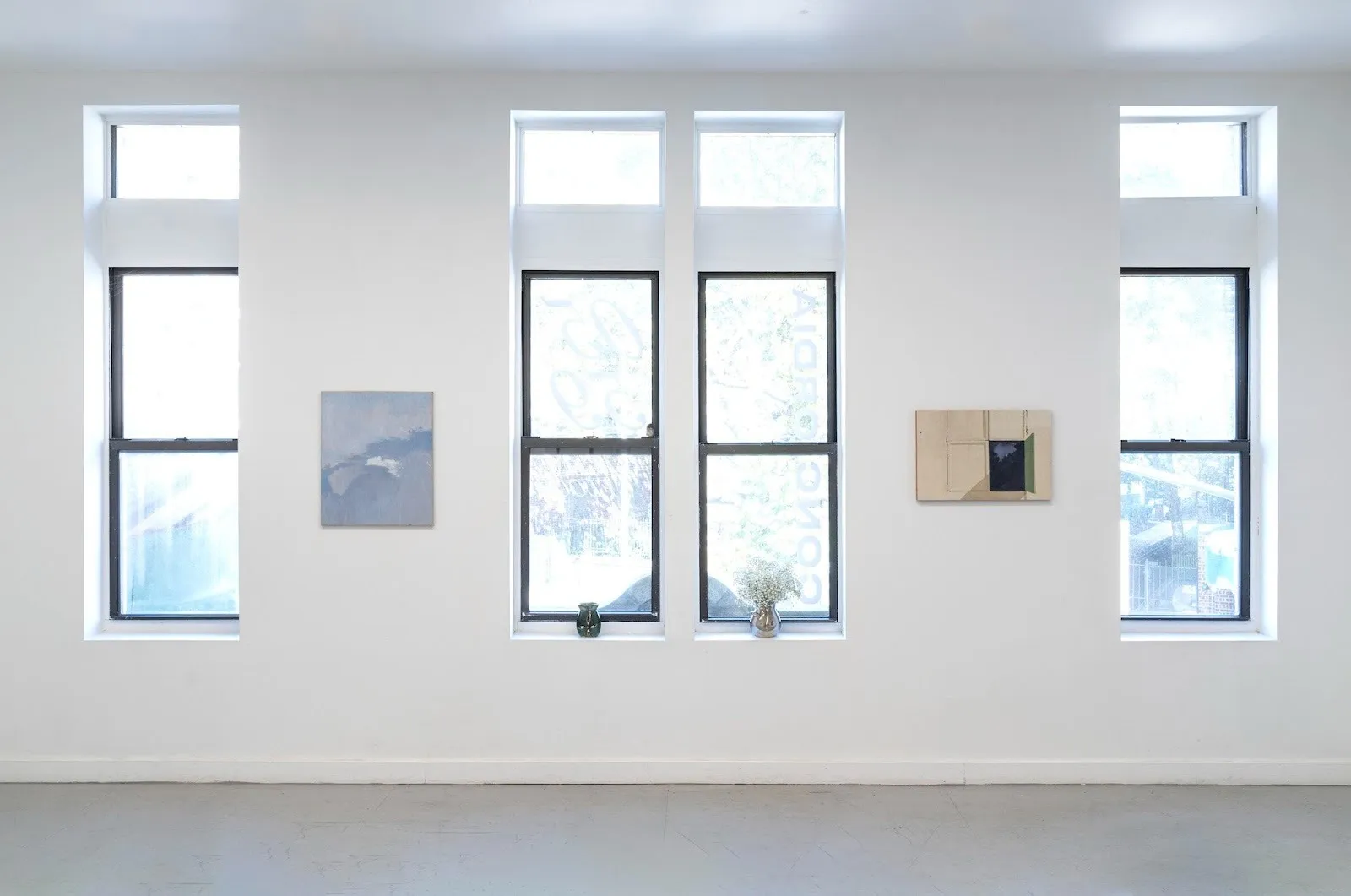 Installation view of painting exhibition by latin american emerging artists that explore passage of time and landscape at NADA gallery, new york, titled 05:59 by Concordia Studio.