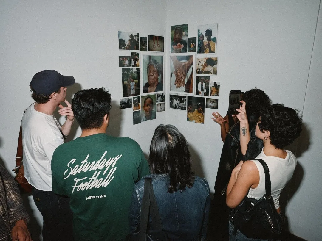 Young artists and creatives taking pictures and looking at Nuvany Davis's photograph installation, boyd, at 25 allen street, opening night of new york now group exhibition.