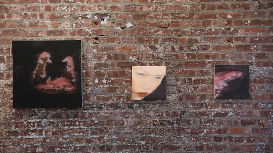 Three dark oil paintings installed on brick Gallery wall, depicting dogs with wet barking mouths and face of a woman, jen deluna bite of another, only briefly, bare, group exhibition obsessed at zepster gallery, pop culture, self perception.