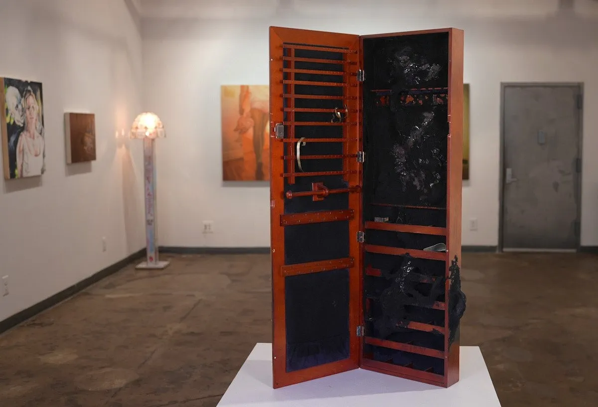 Installation view of group exhibition obsessed at zepster gallery, vanity chest on pedestal, oil paintings and floor lamp, self-perception digital media, pop culture.