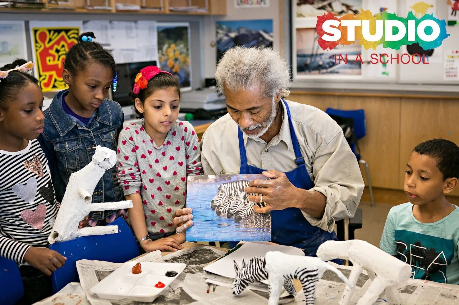 Ceramicist and artist instructor at art education nonprofit studio in a school noel copeland shows four 4th grade students how to paint zebra, ps 133 brooklyn, interview with dr. hasna muhammad.