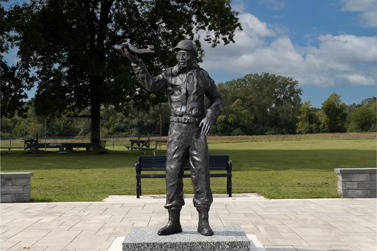 Tuskegee airmen memorial, bronze sculpture of a man wearing uniform, hamlet, and holding up right arm, austen brantley sculpture in rouge park detroit, impulse magazine interview.