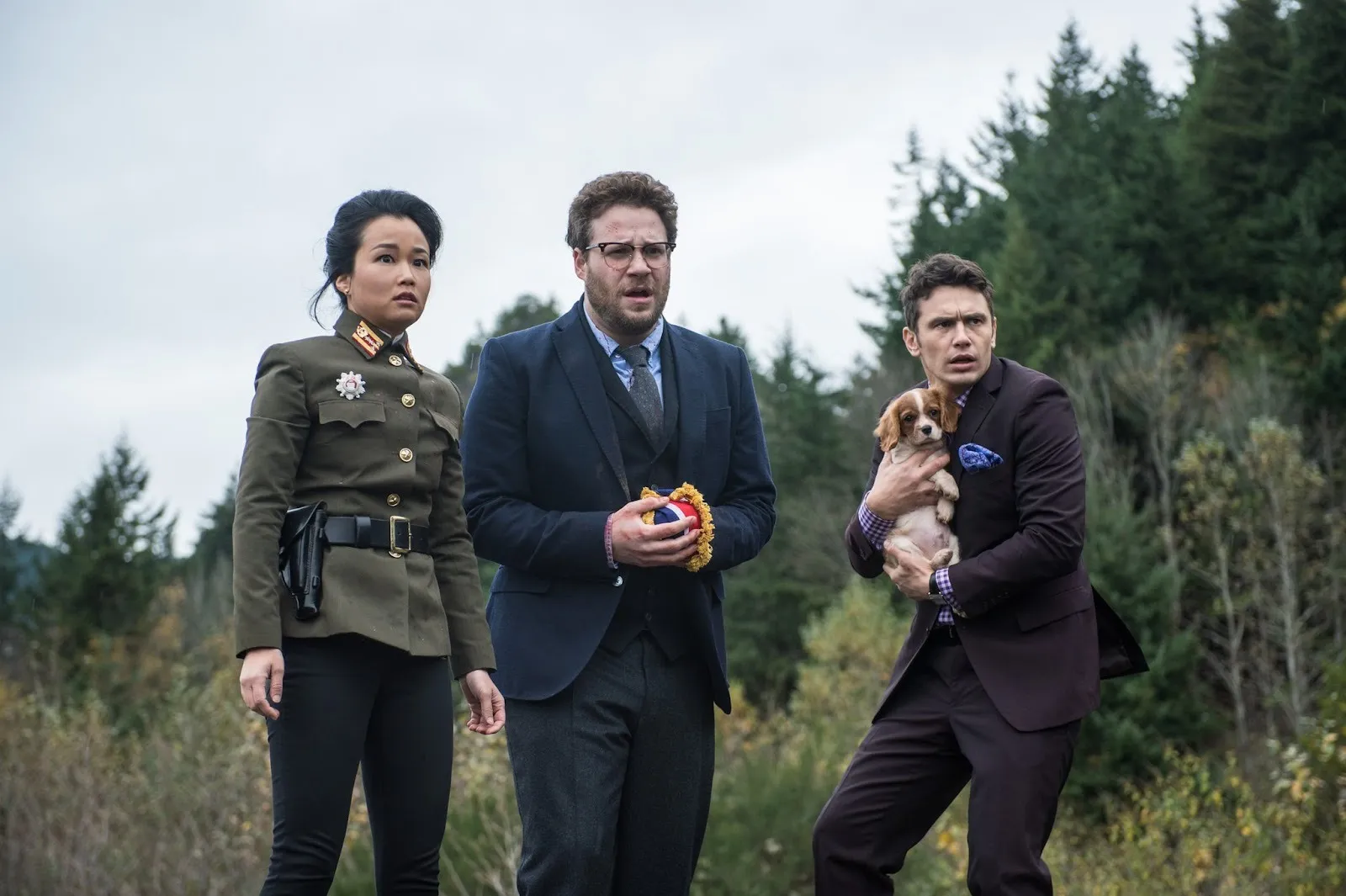 Diana bang, seth rogan, and james franco in the interview 2014 political satire film, two white men, a puppy and one korean woman standing in forest in shock, movie review by lisa kwon.