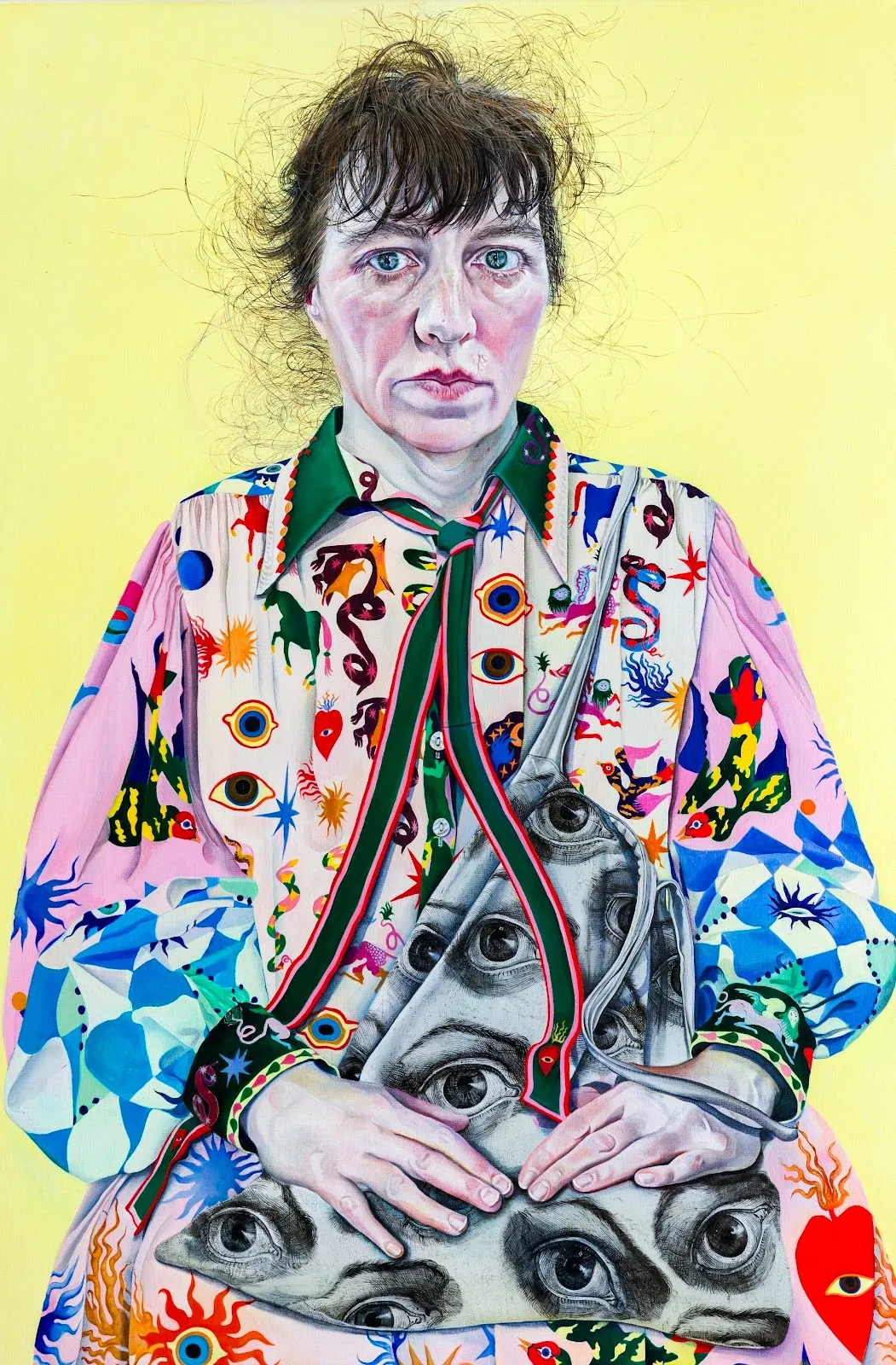 Self-portrait of a seated female figure with hands on her lap. The shirt is colorful with various designs such as sacred hearts, snakes, realistic and stylized eyes, and blue checkerboards.
