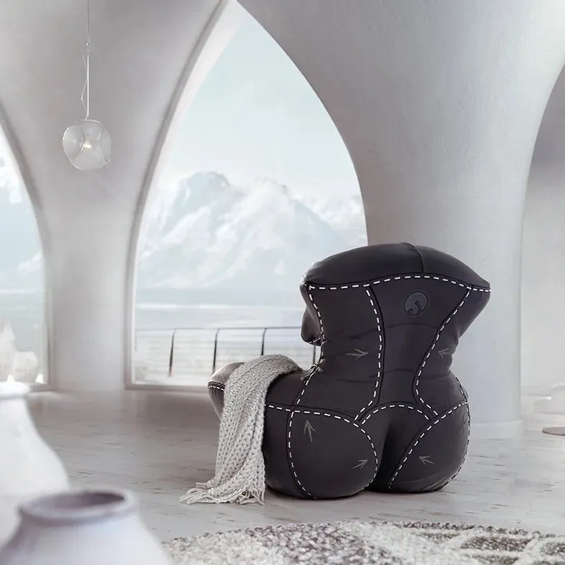 Black leather chair in a beige themed living room, looks like women's body with plastic surgery line, NAGABABA chair by Mariusz Warsinski and Wamhouse Studios.