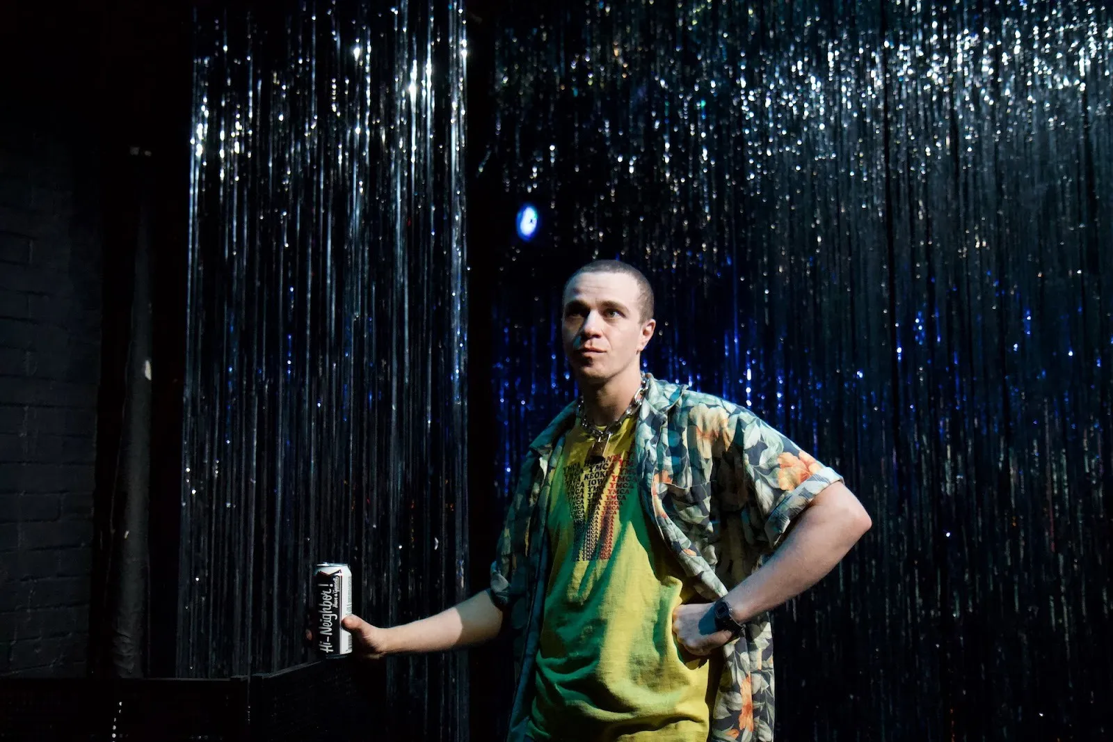 Julian Socha holding soda can in front of glitter background in isle vile at The Tank.