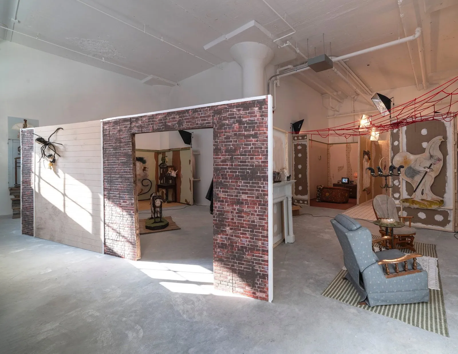 Faux walls, rustic furniture, and zoological motif sculptures at Amy Bravo: TransmogrificationNow! at Swivel Gallery.