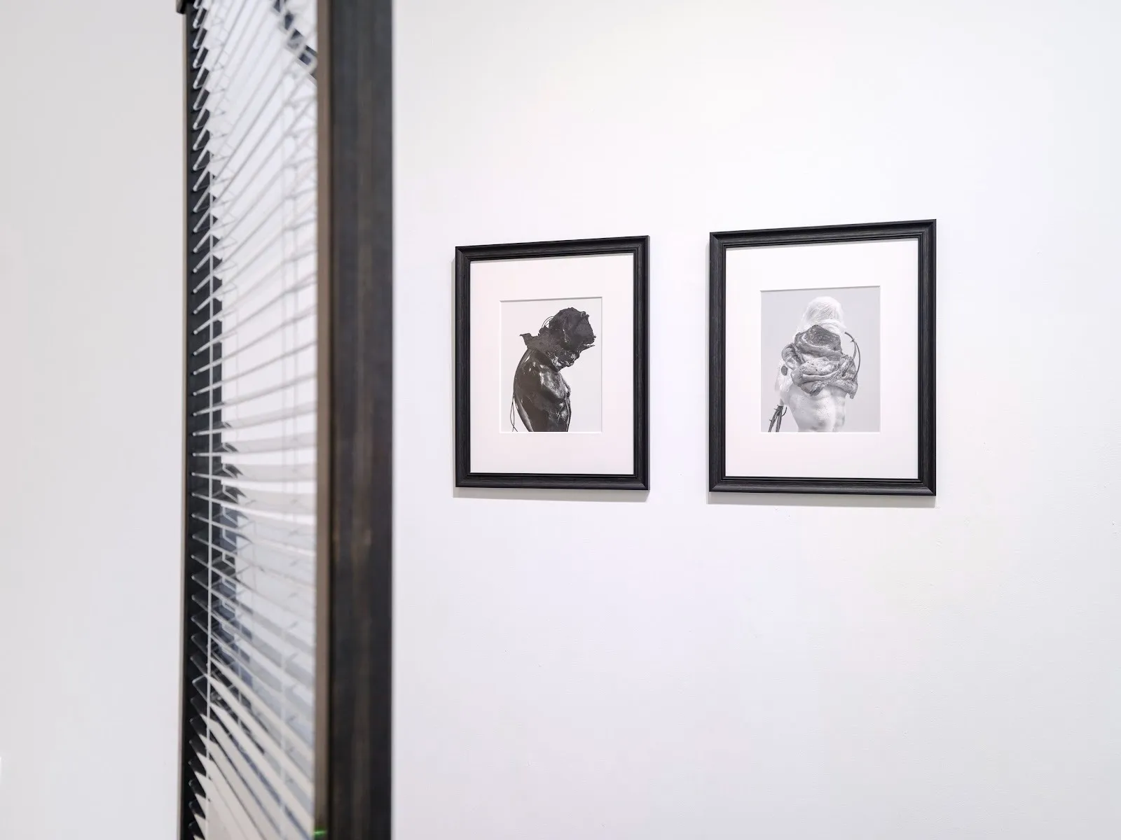 Mirror blinds with transparent mirrored PVC next to two posthuman photographs, peripheral belonging group exhibition at GHOSTMACHINE.
