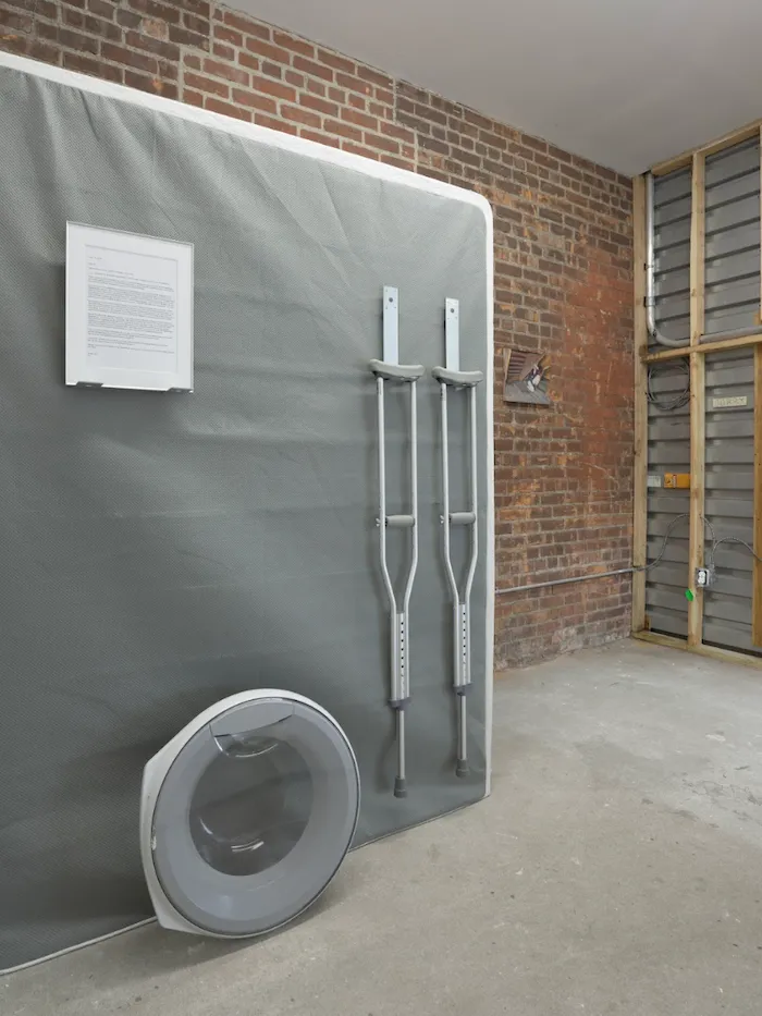 Email printout, crutches, and washing machine door mounted on mattress, Artists & Recipes Marvin Gardens dysfunctional family matters by Jo Shane.