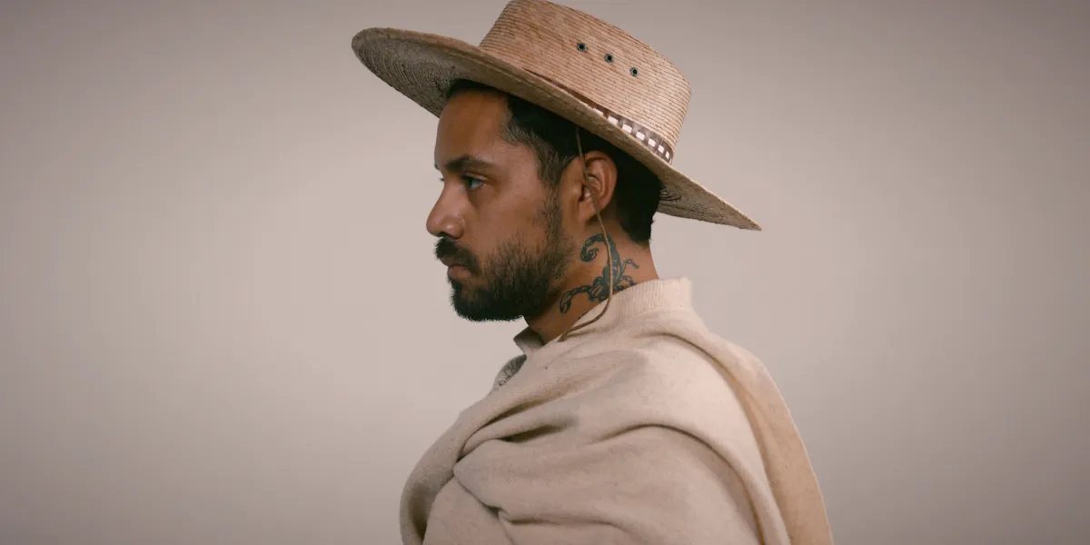 Latin man with hat, poncho, and scorpion tattoo. Heldáy de la Cruz, self portrait in desierto a desierto, Portland artist and designer.