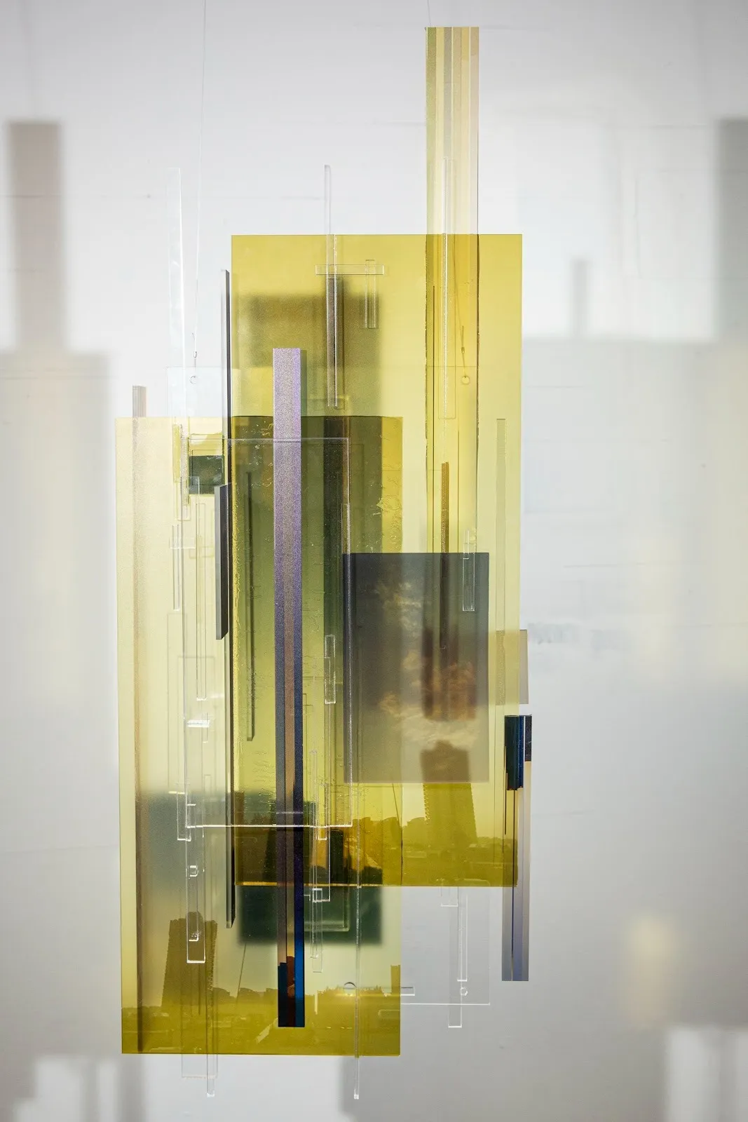 Layers of rectangular acrylic prints with Architectural Components and natural landscape layered on top of each other as a sculpture, Jingyao Huang. Chaotic Data Fences, Baraka, and the Cityscape #2.