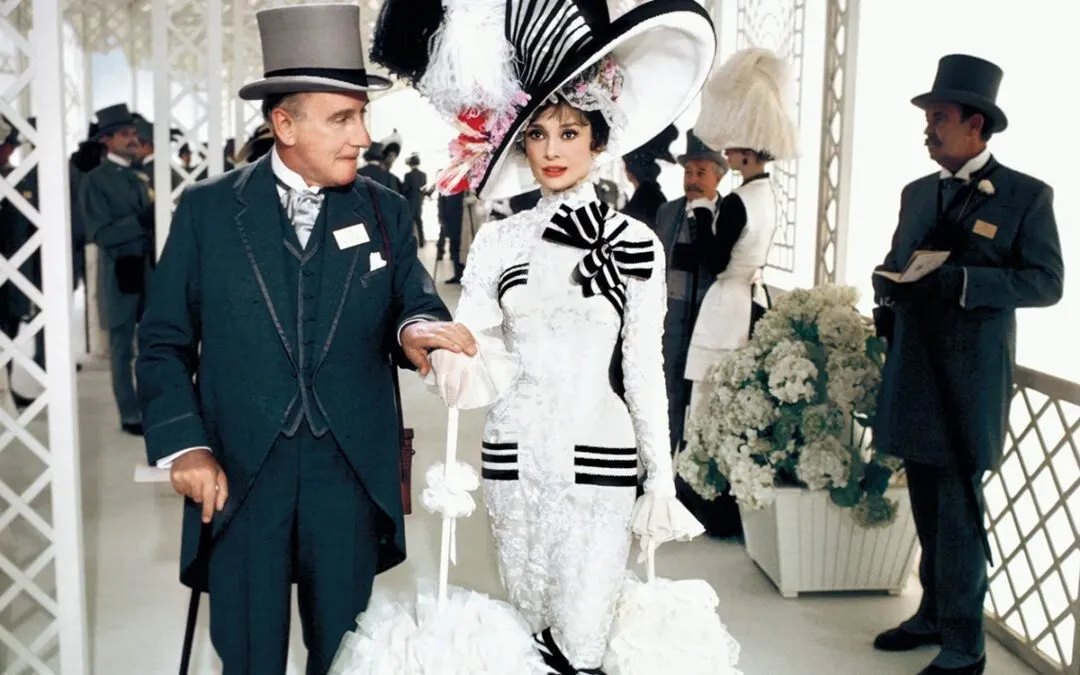 Still from 1964 my fair lady, eliza doolittle sitting at upper class gathering, featuring audrey hepburn, rex harrison, and jeremy brett, impulse magazine film review by tiffany babb.