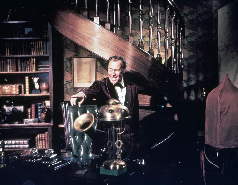 Still from 1964 my fair lady, eliza doolittle's voice coach henry higgins pointing a finger in his study, featuring audrey hepburn, rex harrison, and jeremy brett, impulse magazine film review by tiffany babb.
