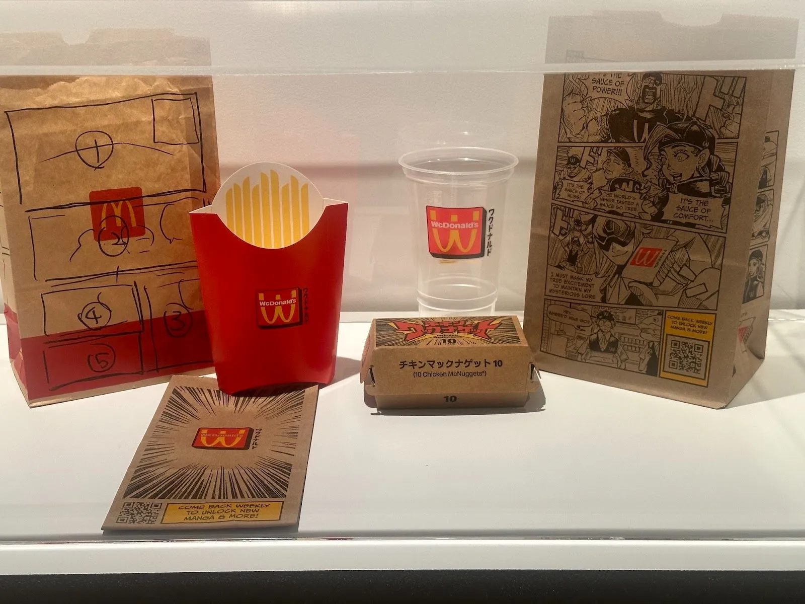 Acky Bright japanese artist solo exhibition studio infinity at japan society, installation view, reviewed by a.e. chapman, mcdonals paper bags and sandwich boxes with black and white drawings.