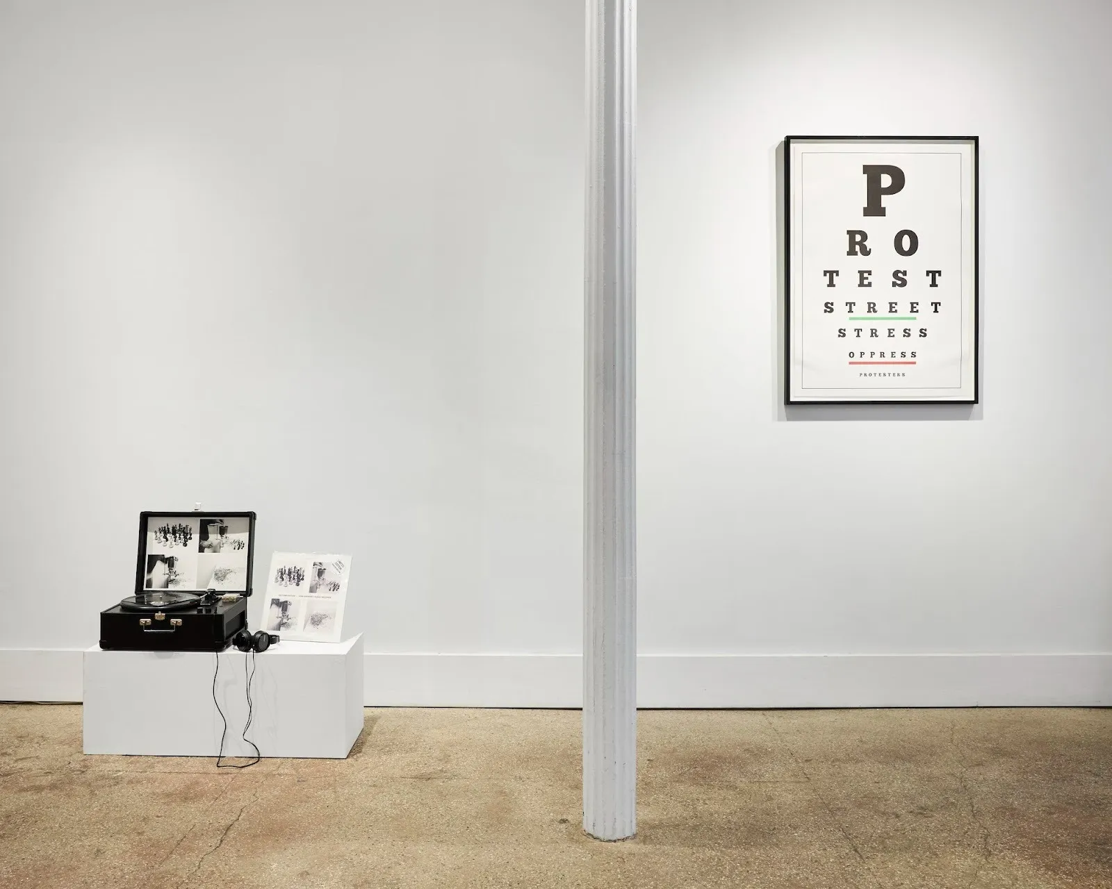 CD player and headphones with black and white photograph on white plinth, poster with vision board letters, ivan navarro solo exhibition small talk, miriam gallery reviewed by emma fiona jones, impulse magazine.