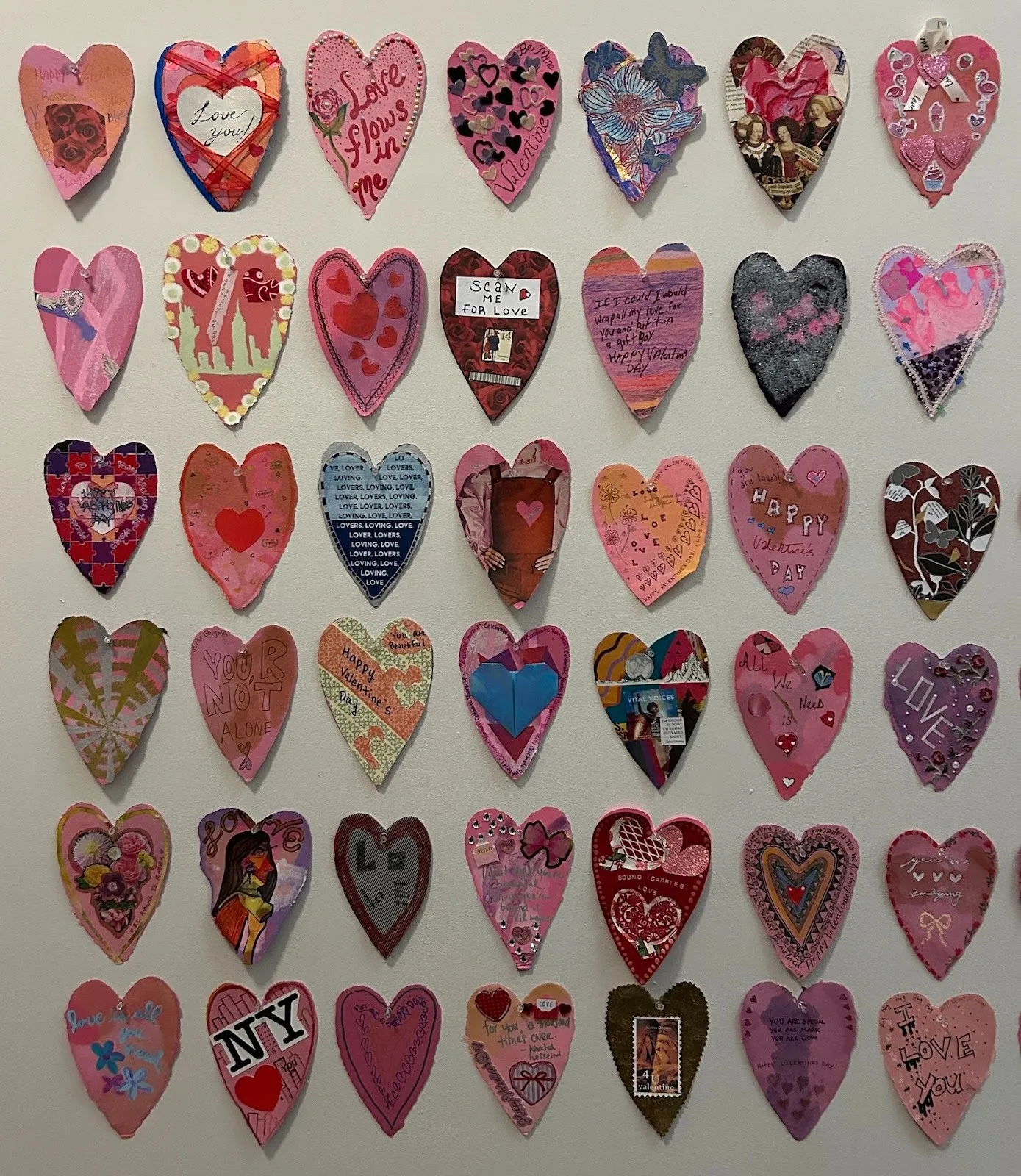 A wall of pink and red Valentine's Day card with encouraging and caring words for HIV positive women, annual Museum installation at MoMA PS1, love positive women.