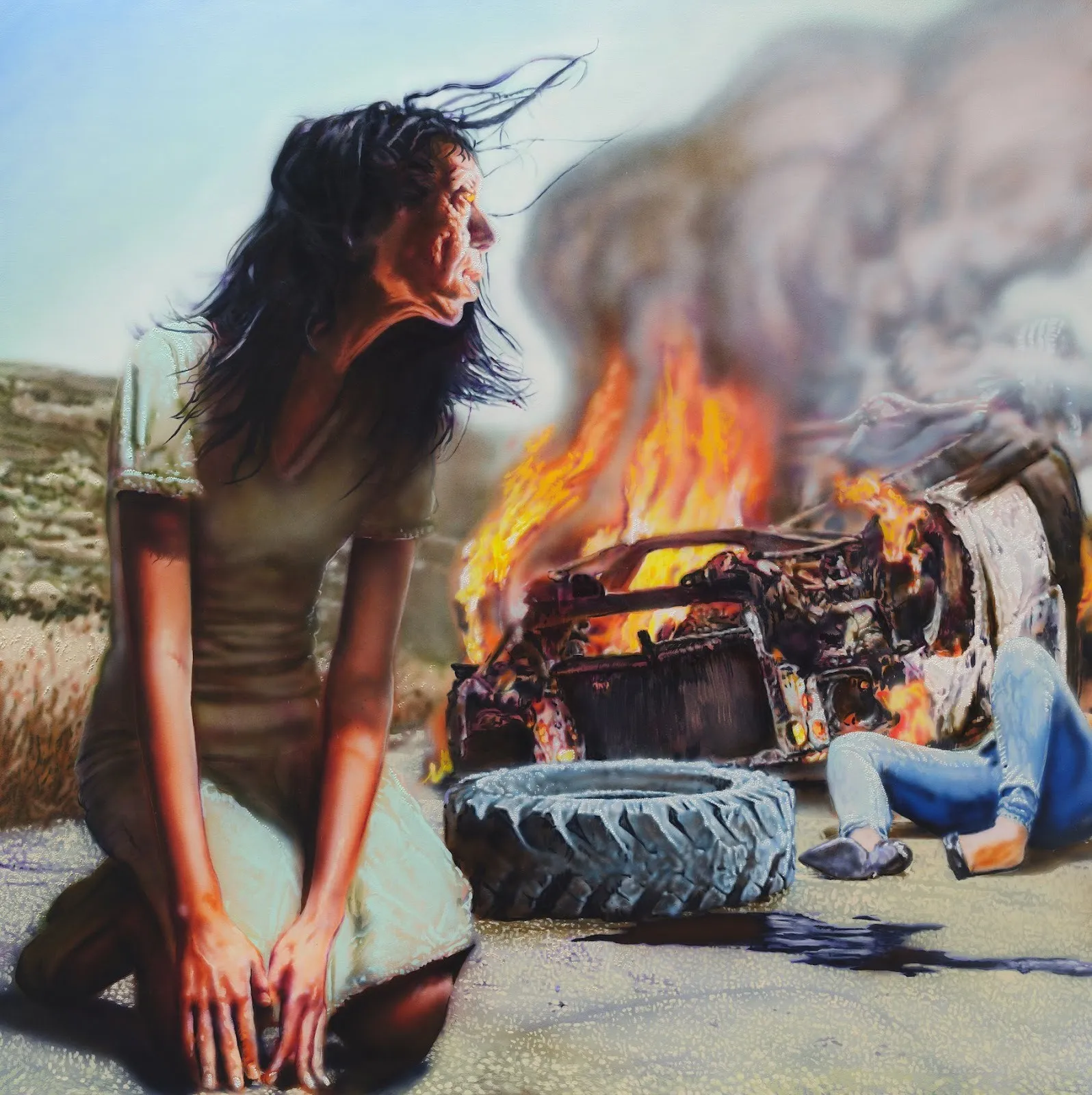 Acrylic painting of woman in pale blue dress kneeling on the road next to car crash, flames engulf car skeleton with lifeless body lying on the ground, and one tire fell, sybil by tim brawner in last caress at management gallery new york.