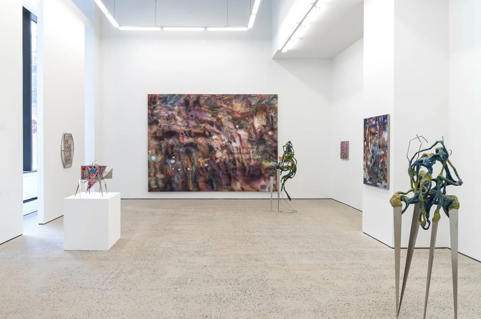 Gallery room with dark purple abstract cosmic painting and sculptures that resemble alien beings, interspecies new scenarios of symbiotic coexistence at swivel gallery.