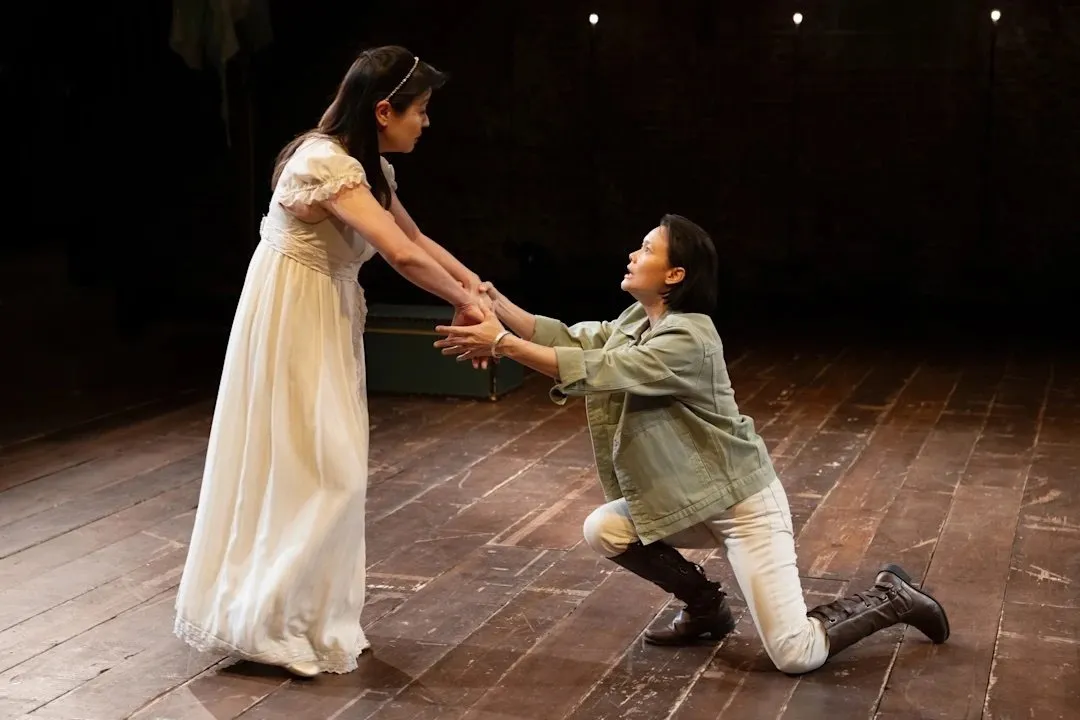 Two asian women and nonbinary actors stand on stage performing a gender-bending version of cymbeline at national asian american theater company.