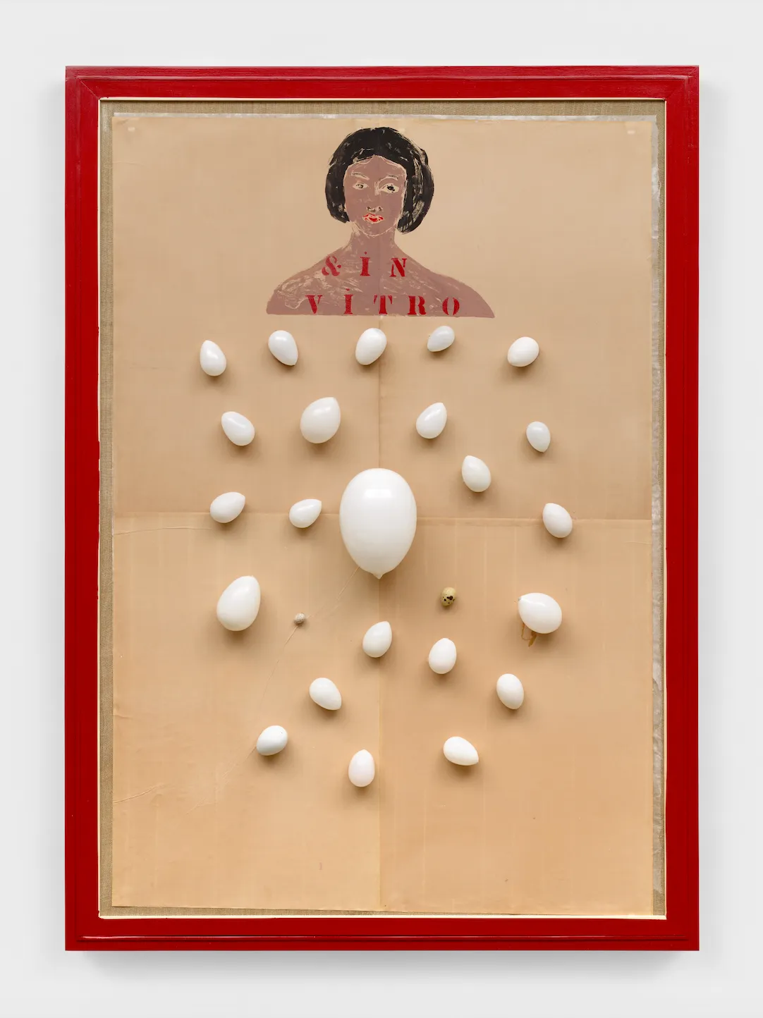 Installation shot of red-framed paper work. On brown paper, the bust of a female-presenting figure has the text "& IN VITRO" written on her neck and chest. White glass bulbs of varying small sizes are scattered in a contained space beneath the bust.