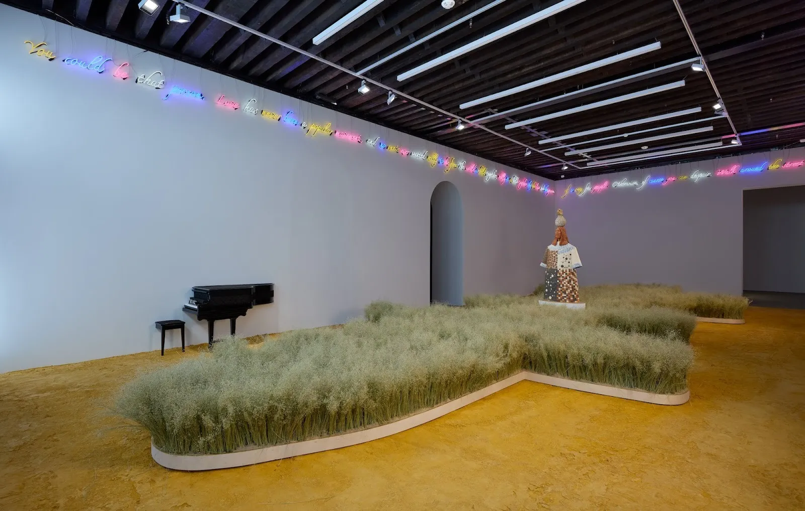 Ceramic sculpture Tower stands in the middle of rice field installation, in white Cube Gallery room with neon lights and half a piano on the wall, Tavares Strachan, The Birth of Exuma (Eagle Talon), starless midnight at marian goodman gallery.