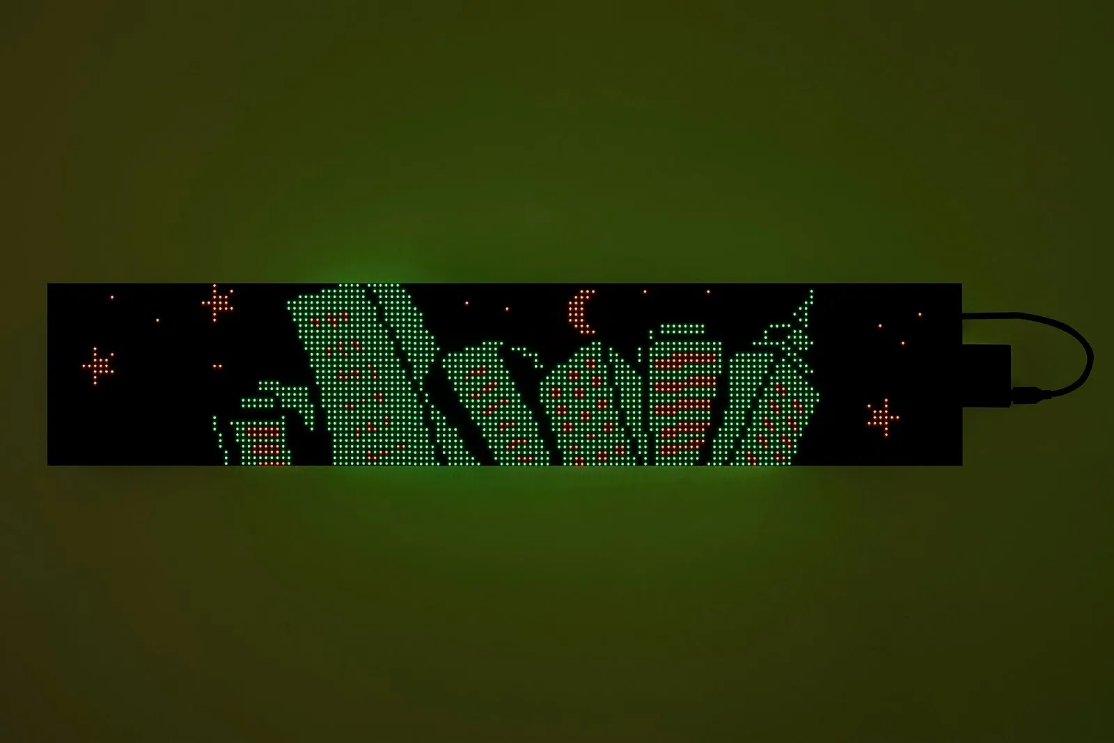 Long LED panel with metropolitan cartoonish graphic and stars and the moon, jacob jackmauh r143 caesura 2025 led matrix panel, admissions at parent company jackmauh solo exhibition.