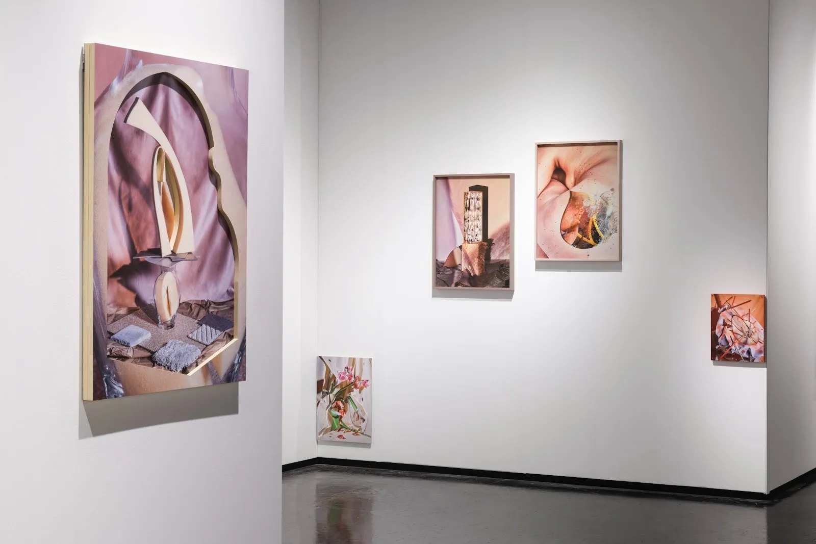 Gallery wall with one large abstract print on the left and three smaller framed works arranged on the right.