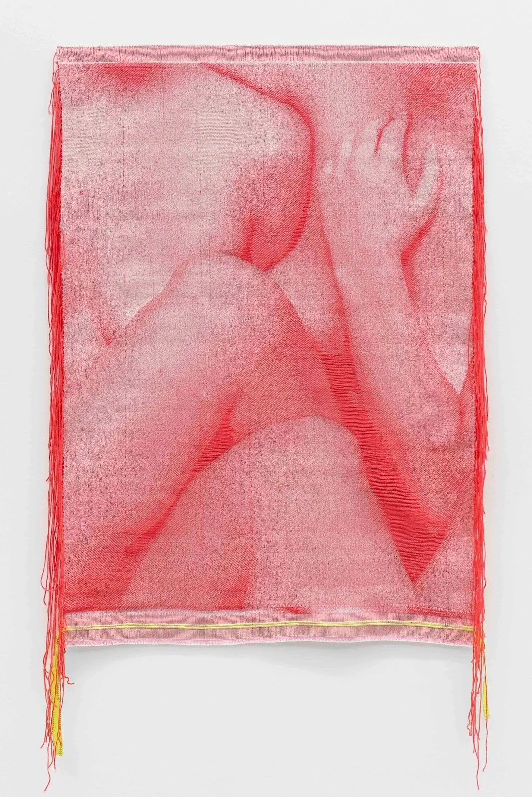 A monochromatic red fiber tapestry mounted to a white wall features the mimetic image of nude body parts wrapped together: hands, legs, and torsos. The borders of the tapestry are made of raw, loose thread.