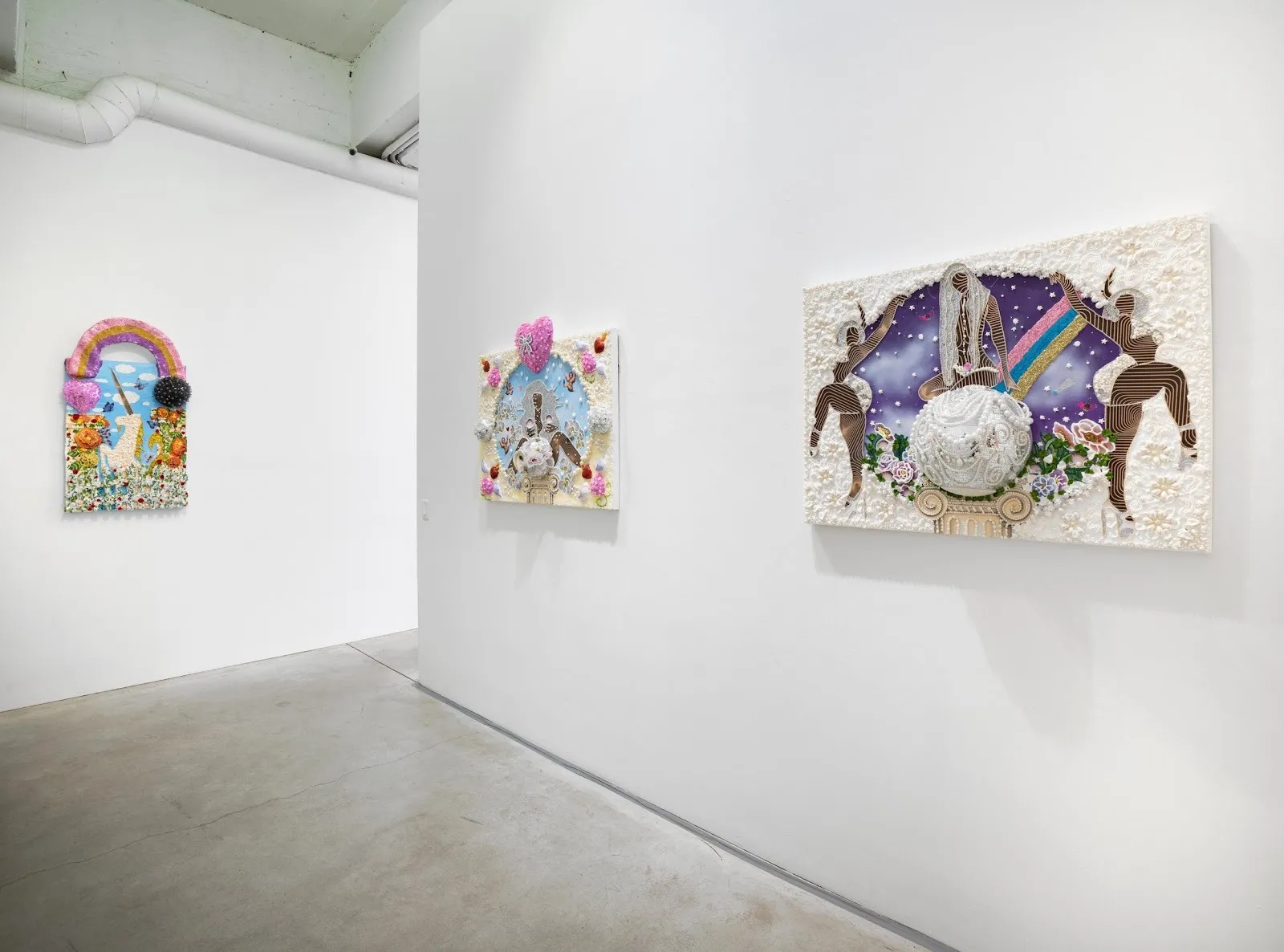 Colorful, textured 2D works are hung on white gallery walls. Each work is colorful and slightly 3D.