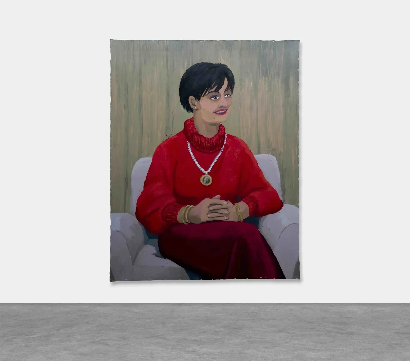 A large painting hung on a white wall depicts a smiling woman in a red sweater with her hands folded in her lap. Her eyes are misaligned and she looks to the side distance.