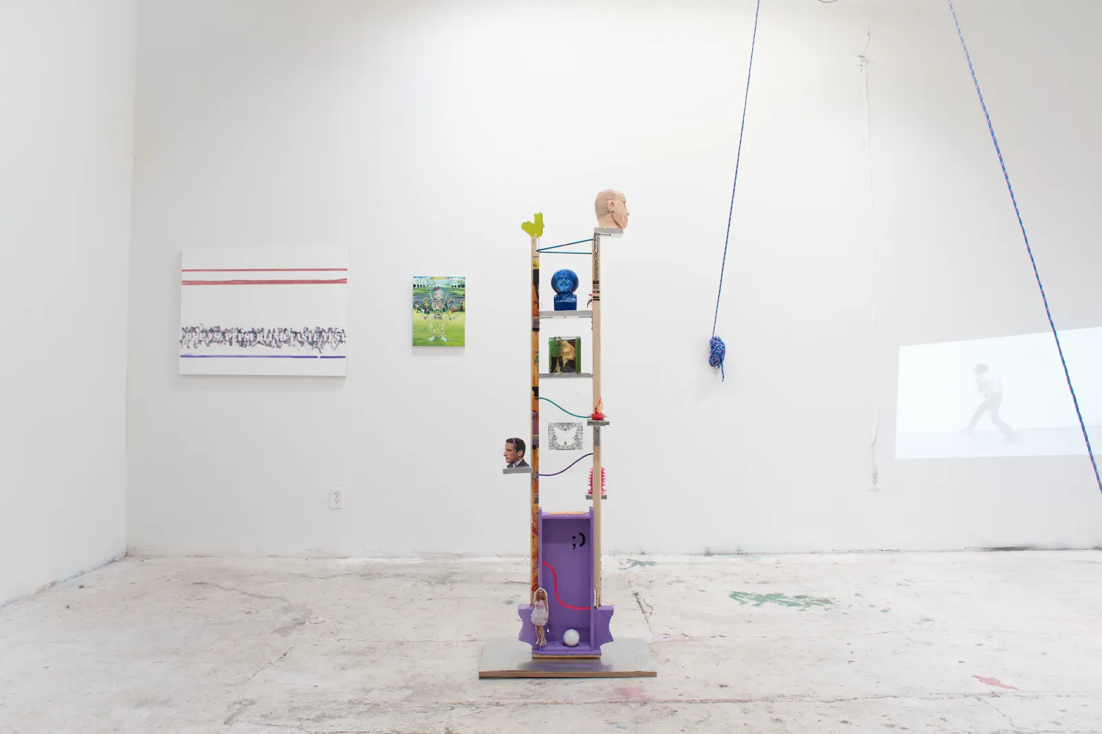 Different abstracted pieces of art, both 2D and 3D, are placed about a white walled gallery space.