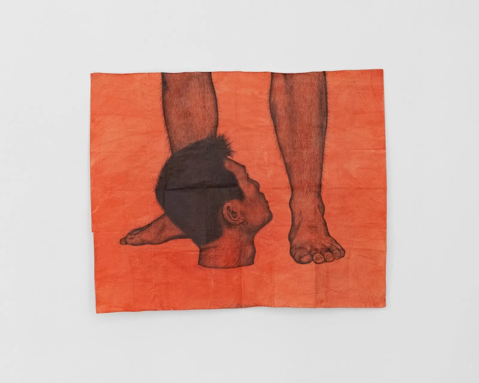 A scarlet-washed work on paper depicts a drawing of a decapitated head, standing in front of the feet and legs of another figure. The head looks up at the figure.