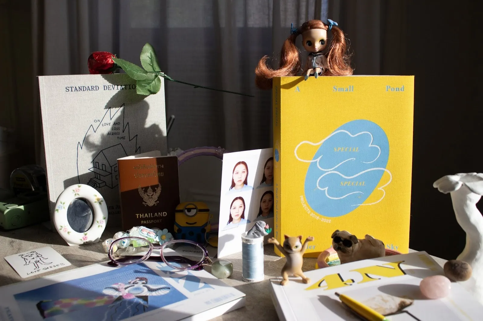 Publications designed by Panny Chayapumh placed alongside miscellaneous personal belongings. Photo by Thanh Bui